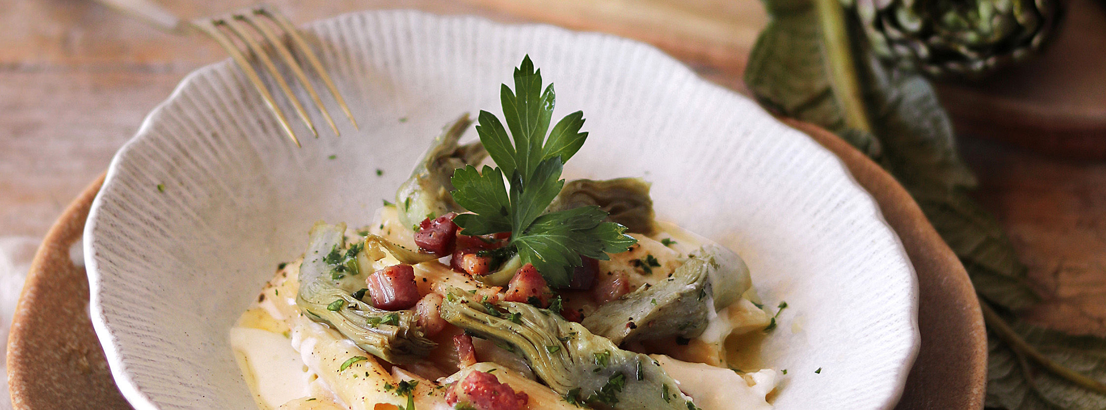 piatto con penne pecorino carciofi e pancetta croccante